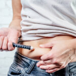 Man injecting insulin in his abdomen with an insulin pen
